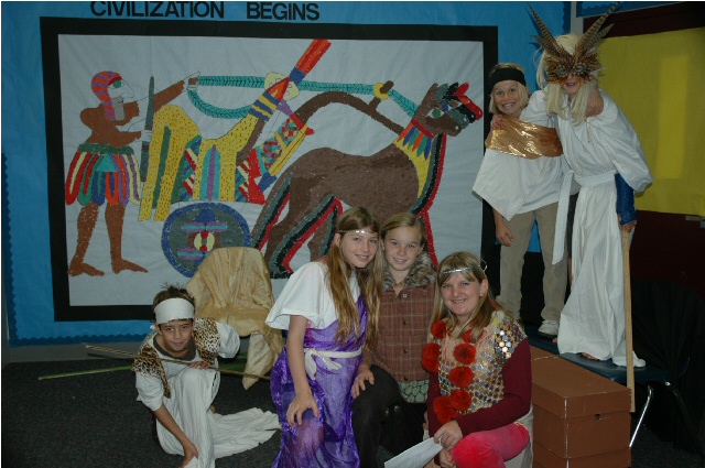 students dressed up for a play posing in front of a mosaic